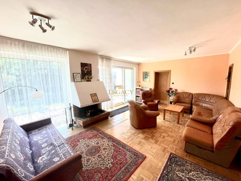 Obývací pokoj s krbem a koženou sedací soupravou v rodinném domě.