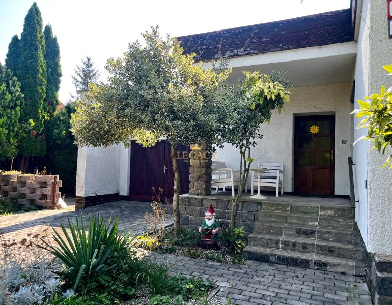 Exteriér rodinného domu v Ivanke pri Dunaji s terasou, zahradním trpaslíkem a stromem.