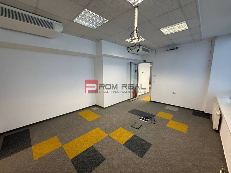 Kanceláře s klimatizací a barevným kobercem, vhodné pro pracovní účely.