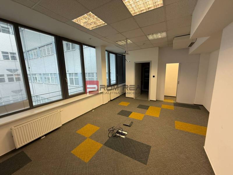 Kanceláře s velkými okny a kobercovými dlaždicemi v odstínech na Cintorínské ulici.