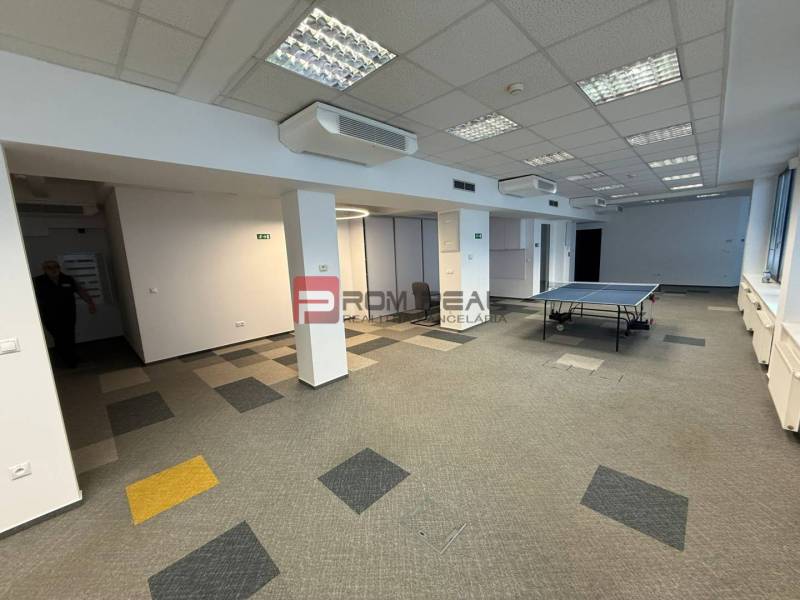 Kanceláře s kobercem a stolním tenisem, prostorné prostředí pro aktivity.