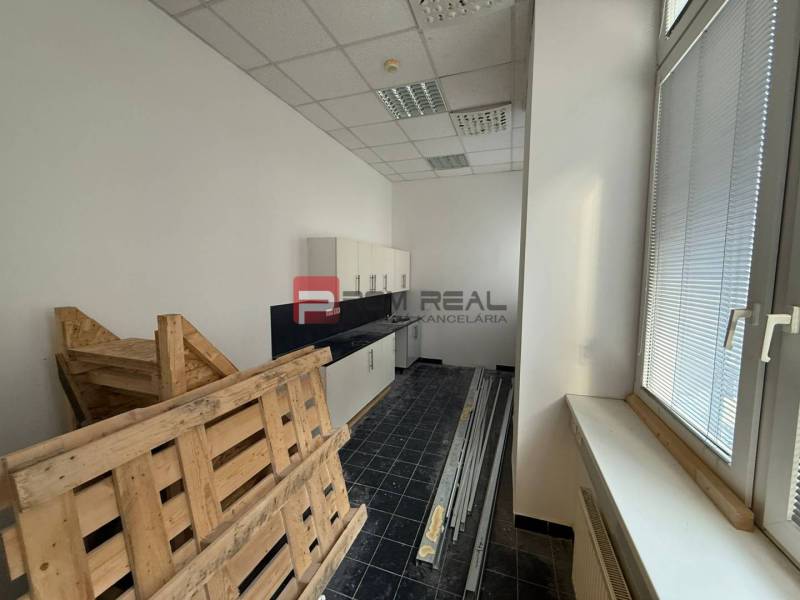 Kanceláře s podlahou z tmavých dlaždic, paletami a skříňkami, ideálně na Hřbitovní.