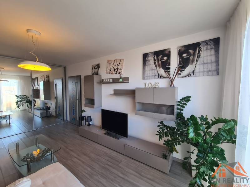 Obývací pokoj v 2pokojovém bytě s podlahou s dřevěným dekorem a dekoračními prvky.