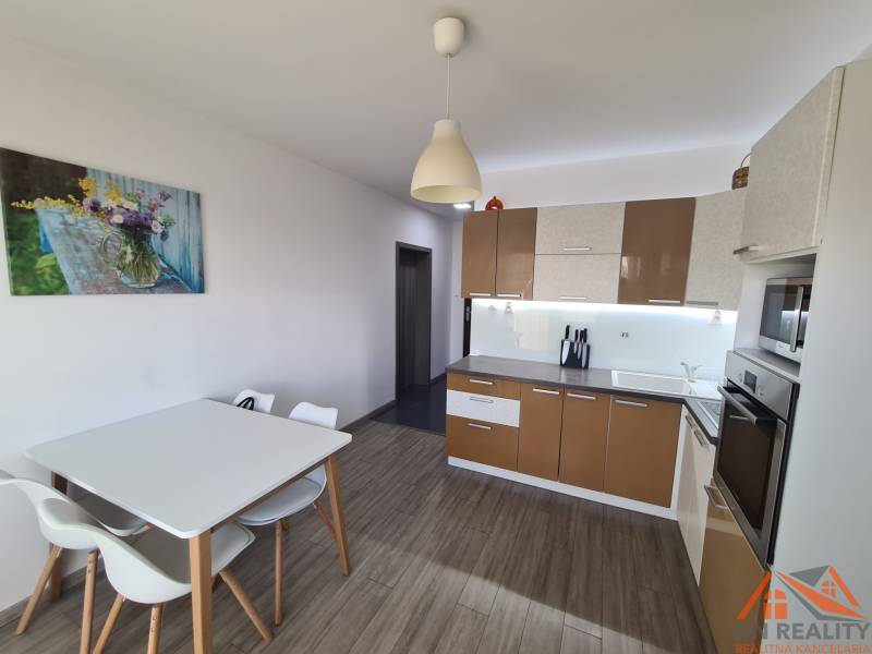 Kuchyně v 2pokojovém bytě s podlahou s dřevěným dekorem a jídelním stolem.