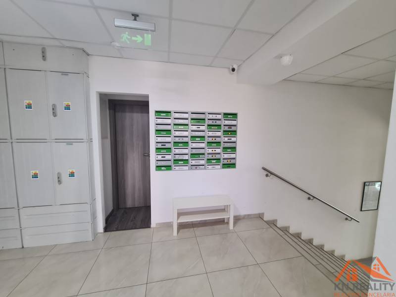 Vstup do 2-pokojového bytu s poštovními schránkami a schodištěm.