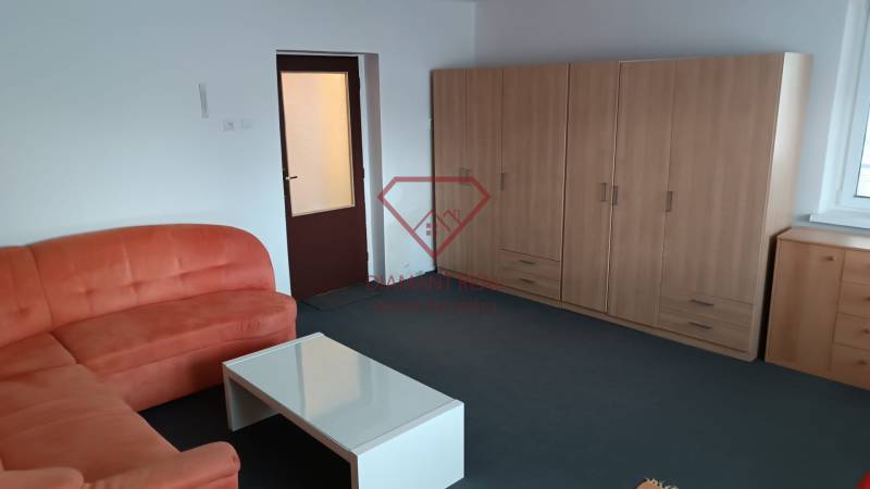 Obývací pokoj v rodinném domě s pohovkou, stolkem a skříní na míru.