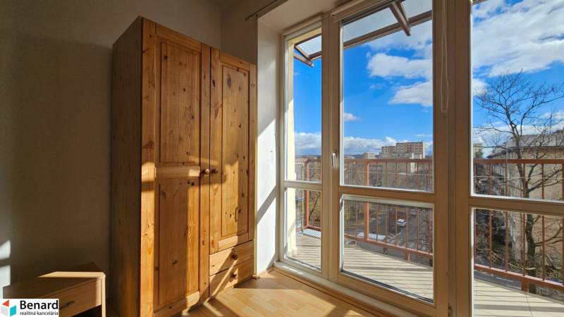 Slunný interiér 2pokojového bytu s podlahou s dřevěným dekorem a dřevěnou skříní.