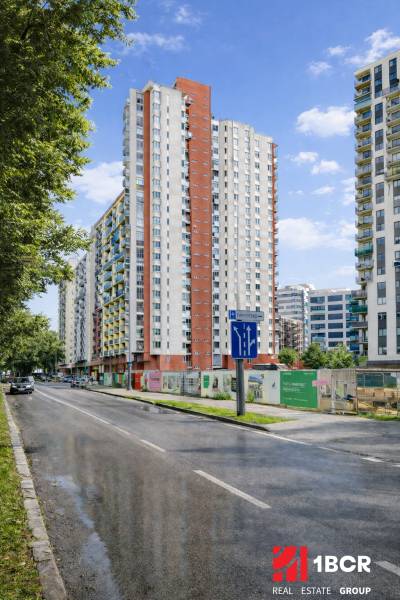 Výškové bytové domy na Jégého ulici v Bratislavě - Ružinově, vedle cesty s auty.