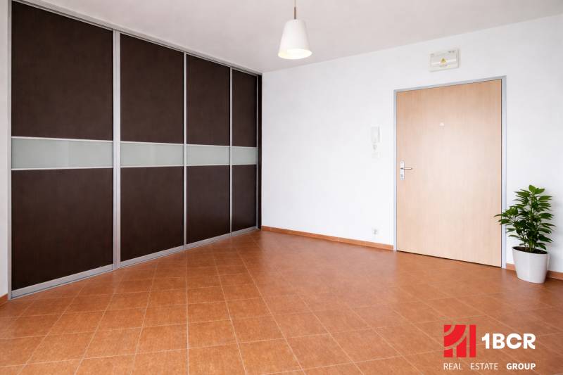 Prostorný vstup s vestavěnou skříní a dlažbou v 2pokojovém bytě.