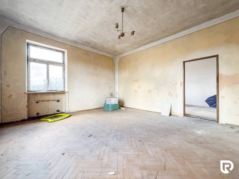 Pokoj v rodinném domě s podlahou s dřevěným dekorem a jednoduchým osvětlením.