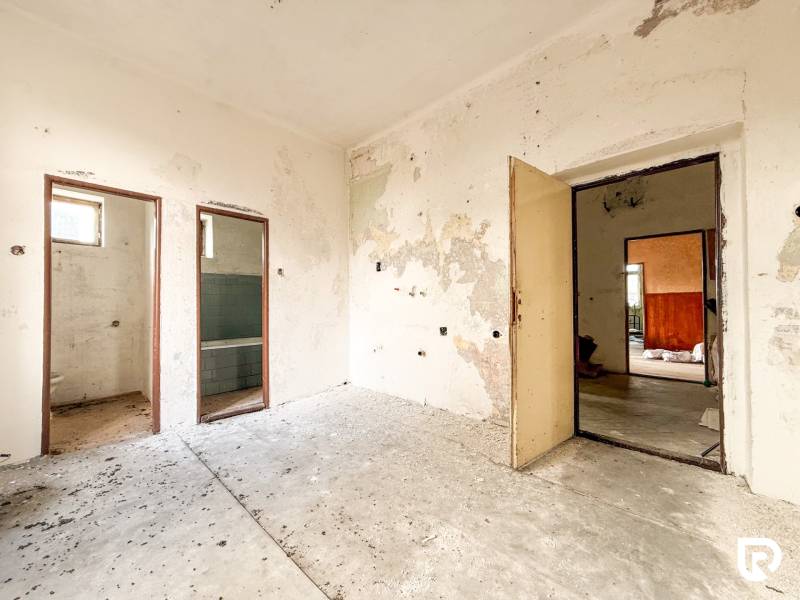 V rodinném domě je starý pokoj s opotřebovanými stěnami a odkrytými prostory.