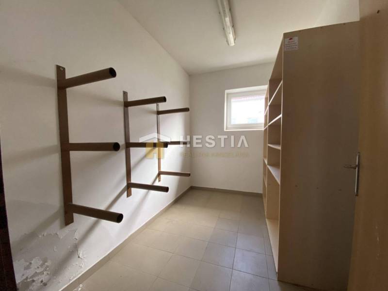 Úložný prostor s vertikálními kovovými regály a policí ve skladech a halách.