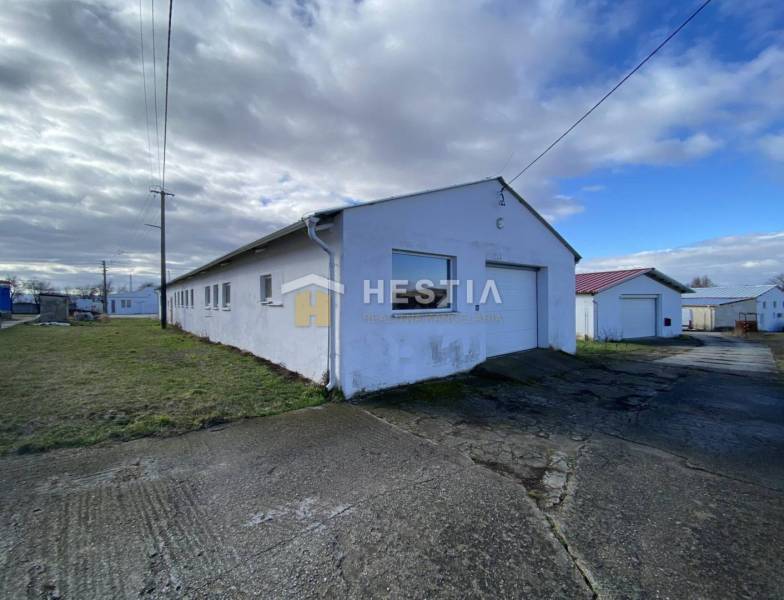 Sklady a haly v Rybkách s travnatým okolím pod oblačnou oblohou.