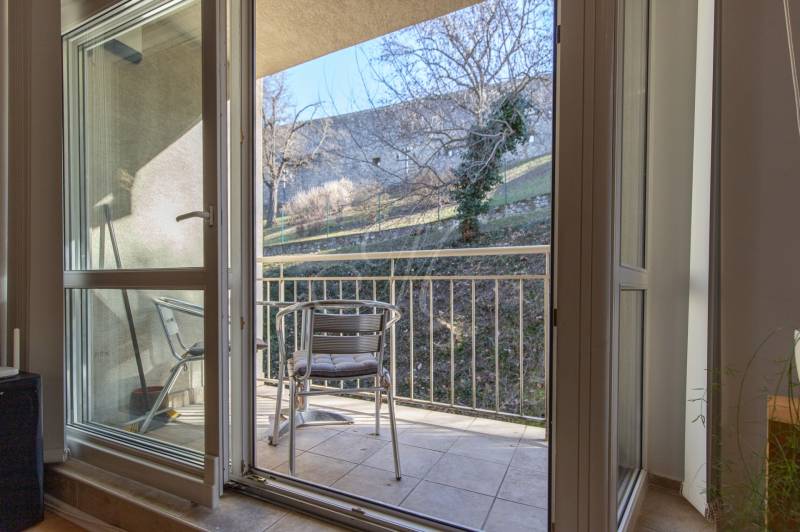 Balkon 3pokojového bytu se dvěma kovovými židlemi, vedoucí do zahrady.