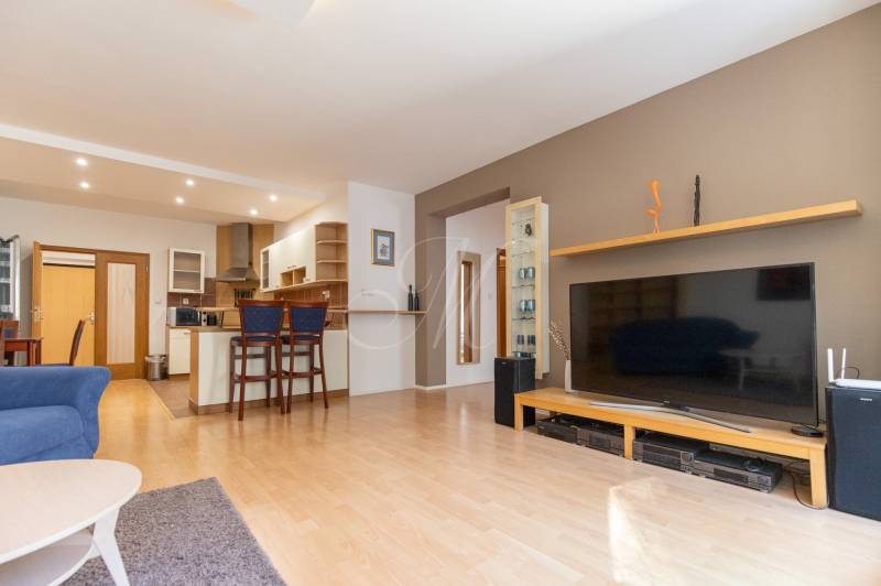 Obývací pokoj v 3-pokojovém bytě se zařízením a podlahou s dřevěným dekorem.