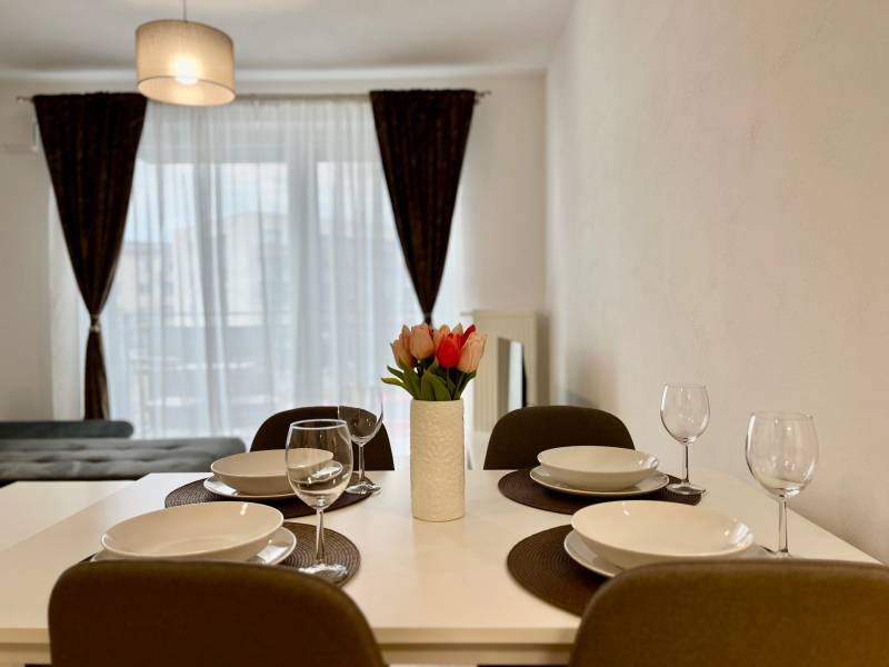 Jídelní stůl v 2-pokojovém bytě se stylovým dekorem a květinami.