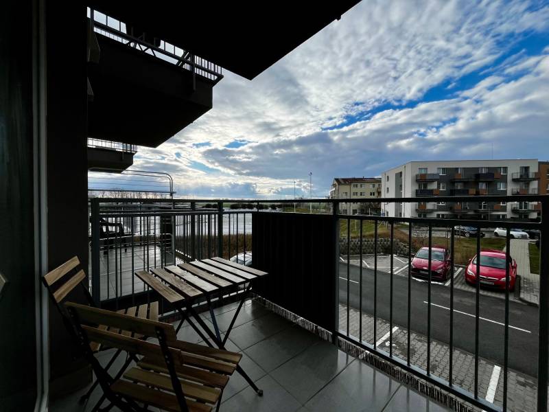Balkon 2-pokojového bytu v Bielom Kostole s výhledem na parkoviště a oblohu.