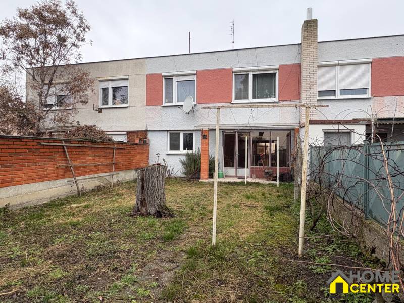 Dvojpodlažní rodinný dům v Zlatné na Ostrově s prostornou zahradou a červenou zídkou.