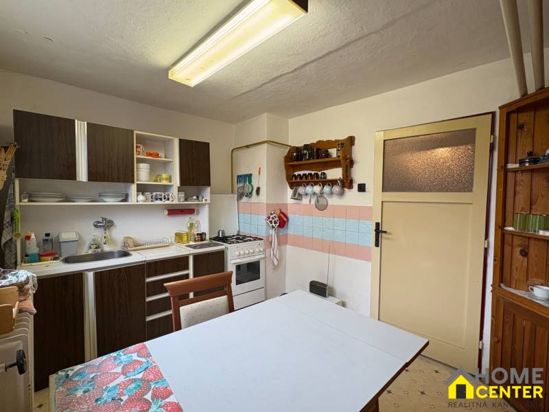 Kuchyně v rodinném domě s jídelním stolem a kuchyňským koutem.