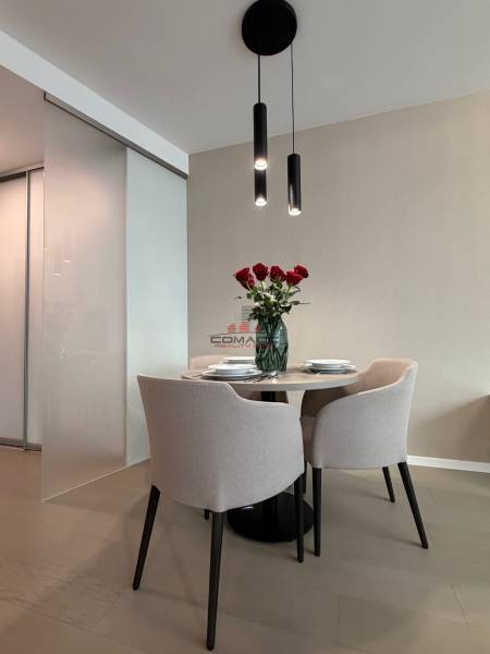 Jídelní kout se stolem a židlemi, podlaha s dřevěným dekorem ve 2pokojovém bytě.