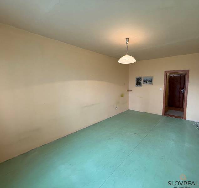 Pokoj v 3-pokojovém bytě s neutrálními stěnami a světlou podlahovou dekorací.