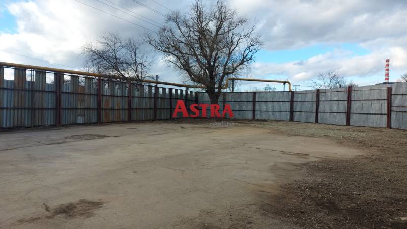 Komerční pozemky v Košicích - městské části Jih s oplocením a stromy.