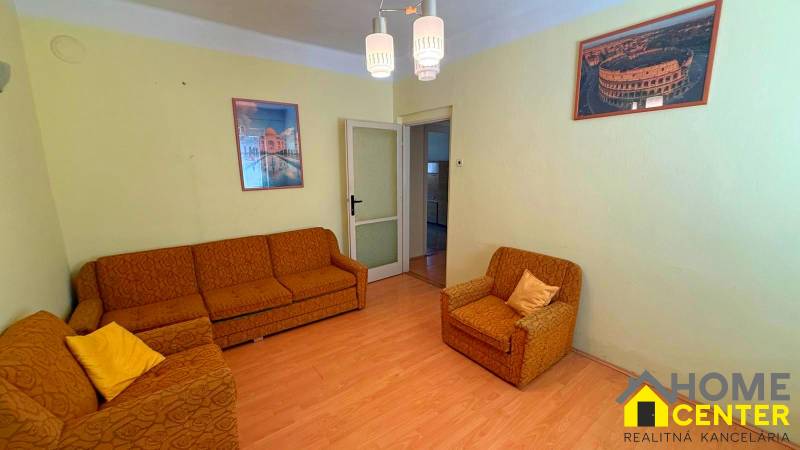 Obývací pokoj v rodinném domě s oranžovým nábytkem a podlahou s dřevěným dekorem.