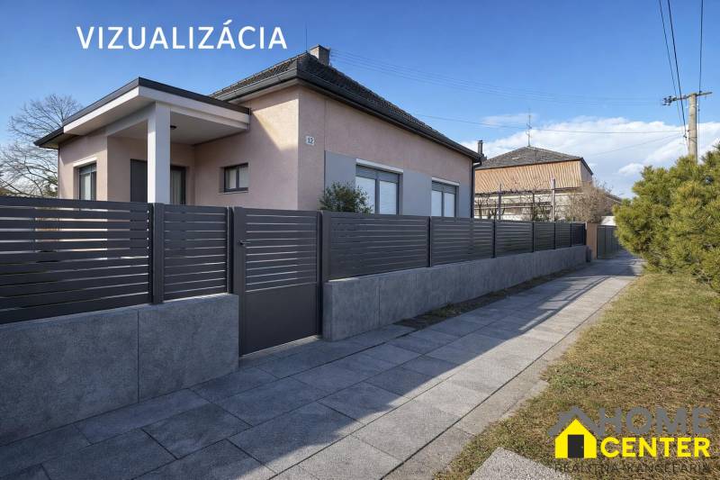 Rodinný dům v Iži s moderním plotem a upraveným chodníkem.
