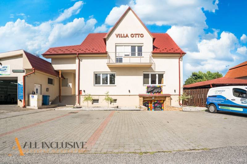 Budova s červenou střechou a vyhrazeným parkováním v Dunajské Stredě.