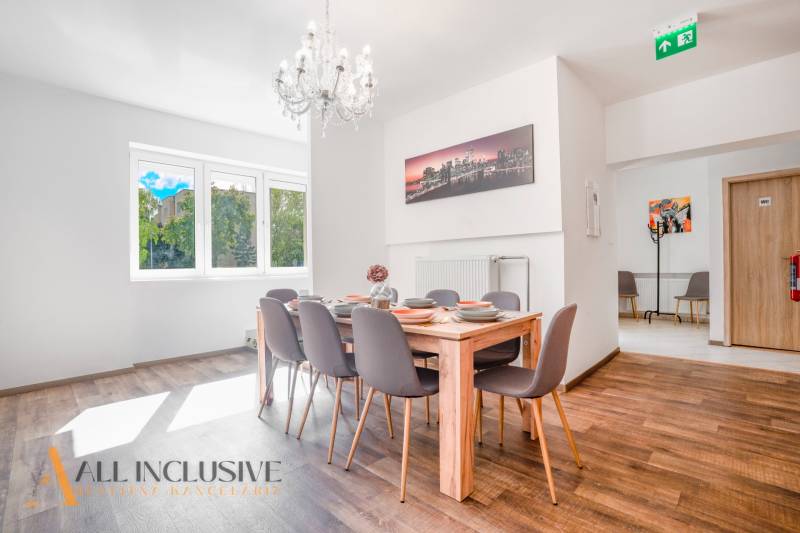 Jídelna s lustrem a podlahou s dřevěným dekorem v budově.