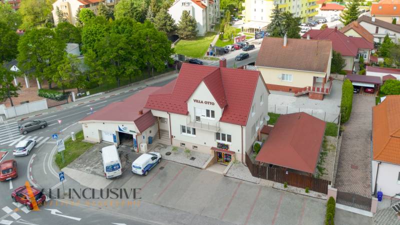 Budova Villa Otto v Dunajské Stredě s červenou střechou a parkovištěm.