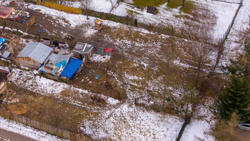 Zahrady v Nálepkově s ledovým sněhem, staršími přístřešky a oploceními v zimě.