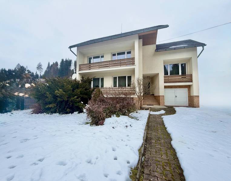 Rodinný dům na Čadečce v Čadci obklopuje zasněžená zahrada a bezúdržbové keře.