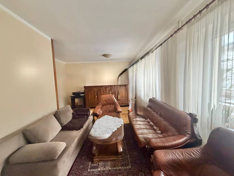 Obývací pokoj s pohovkami a konferenčním stolkem v rodinném domě.