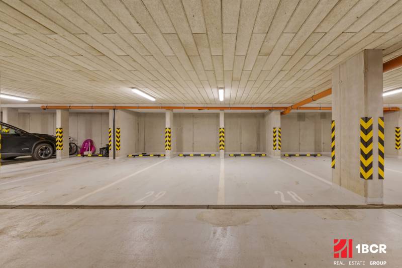 Podzemní parkovací místa s označenými sloupy ve barevném označení.