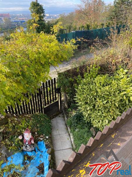 Zahrada u chaty ve Vyšném Opátském s chodníkem, zelení a zahradní dekorací.