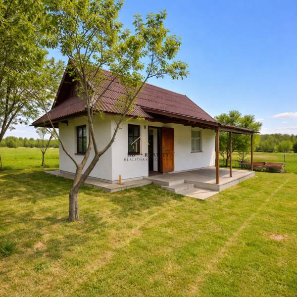 Chata v Obeckově obklopená zelenými loukami a stromy pro klidný odpočinek.