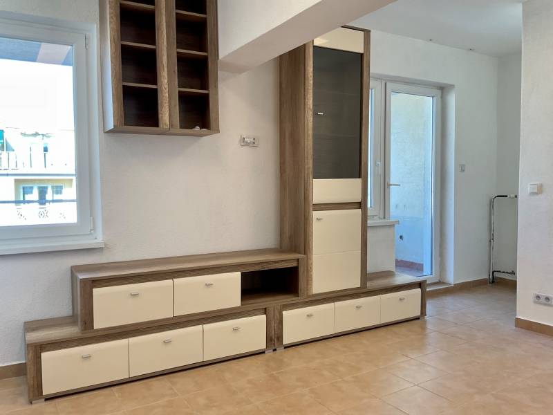 Obývací prostor v 1-pokojovém bytě s nábytkem a keramickou podlahou.