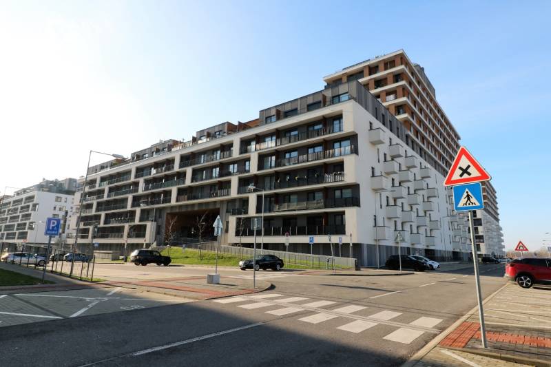 Budova na ulici Zuzany Chalupové v Bratislavě - Petržalce s parkovacími místy.