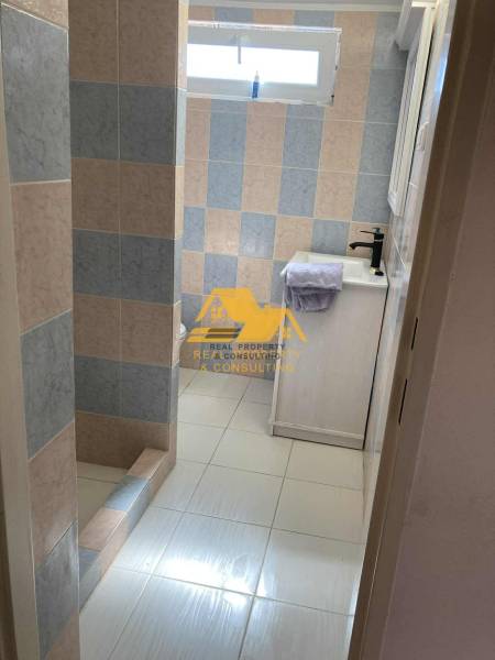 Koupelna v chatě s barevnými obklady a sprchovým koutem se zástěnou.