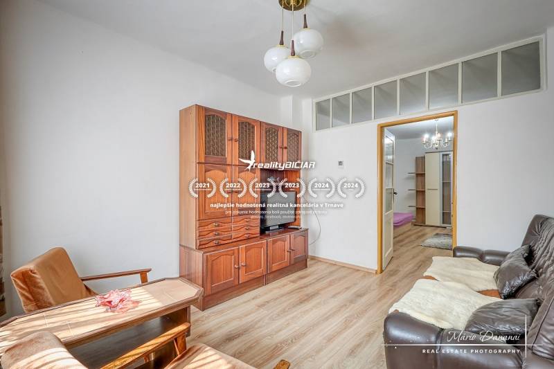 Obývací pokoj v rodinném domě s dřevěným nábytkem a pohodlným sezením.