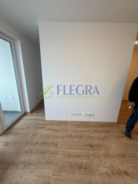 Interiér v 1-pokojovém bytě s podlahou s dřevěným dekorem a balkonem.