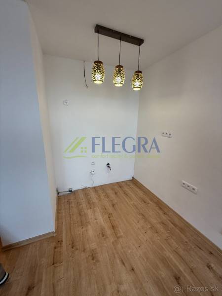 Interiér 1-pokojového bytu s podlahou s dřevěným dekorem a závěsnými svítidly.