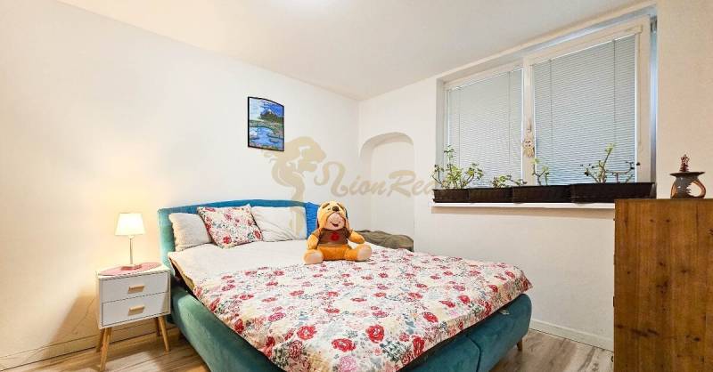 Ložnice v rodinném domě s květinovým vzorem postele a dekoracemi.