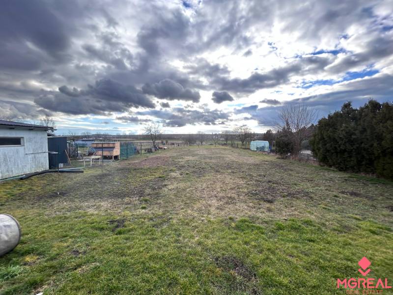 Pozemek u rodinného domu ve Zbechách, s výhledem na rozlehlou zahradu a oblohu.