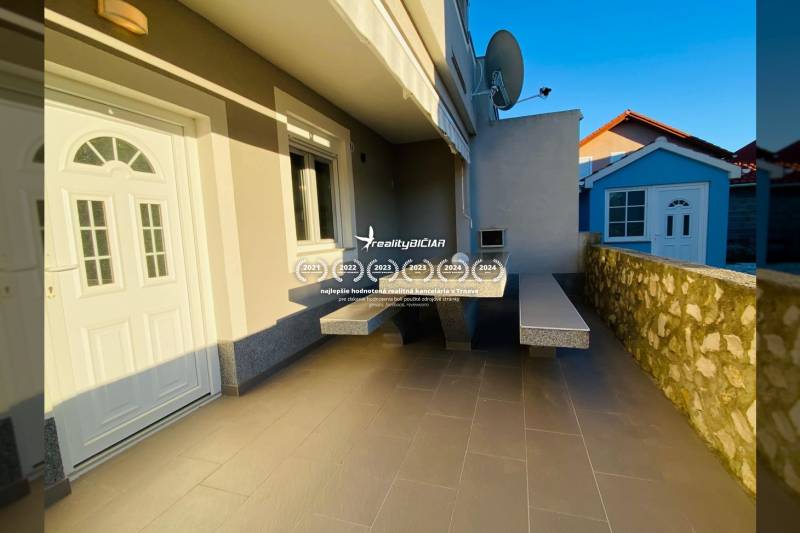 Rodinný dům v Nine na ulici Grbi má terasu s kamennou zdí a satelitní anténou.