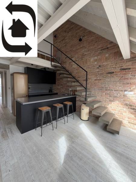 Kuchyňský kout s barem a schodištěm ve 4-pokojovém bytě, podlaha s dřevěným dekorem.