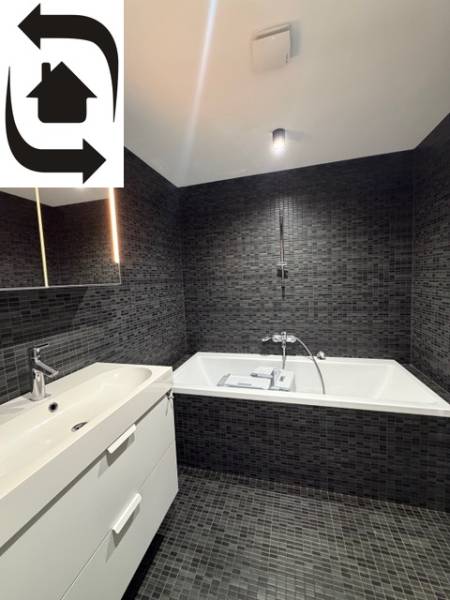 Elegantní koupelna s tmavými obklady a vanou ve 4-pokojovém bytě.