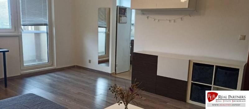 Obývací pokoj v 2-pokojovém bytě s podlahou s dřevěným dekorem a nábytkem.