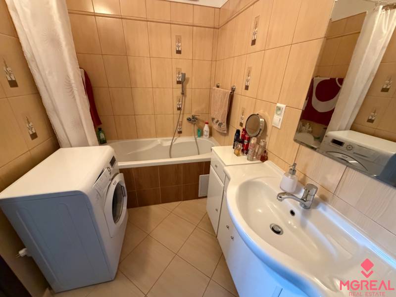 Koupelna se sprchou a vanou v 3-pokojovém bytě, s pračkou a umyvadlem.